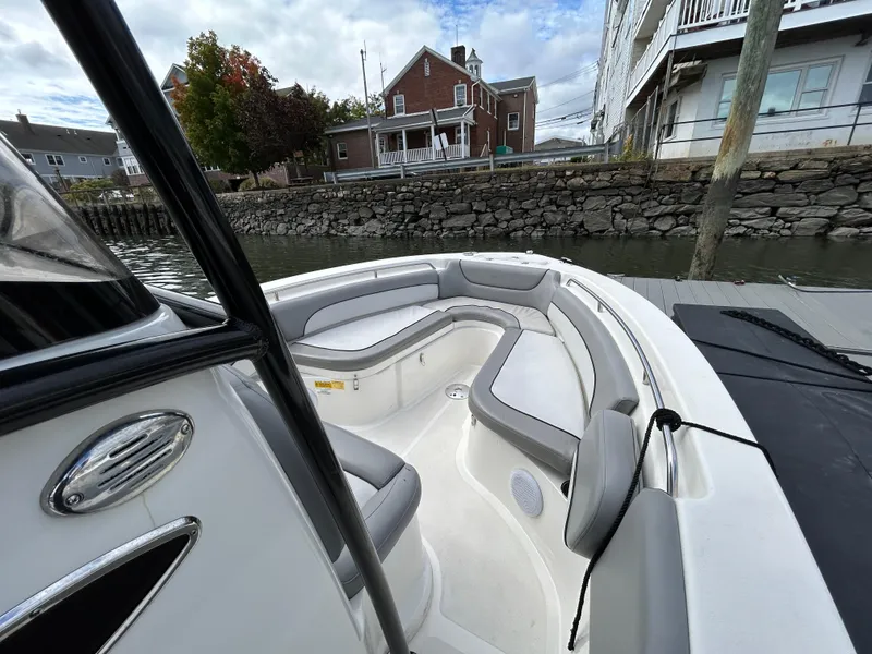 Slide: The Image of 2021 NauticStar 2302 Legacy boat with spacious seating, docked near waterfront homes. - 27