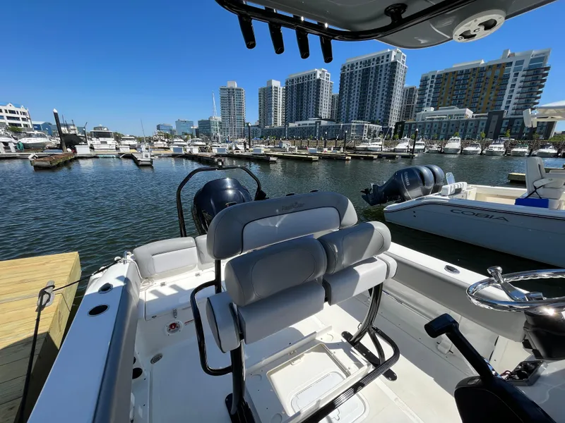 Slide: The Image of 2021 NauticStar 2302 Legacy boat docked in a marina with city skyline. - 31