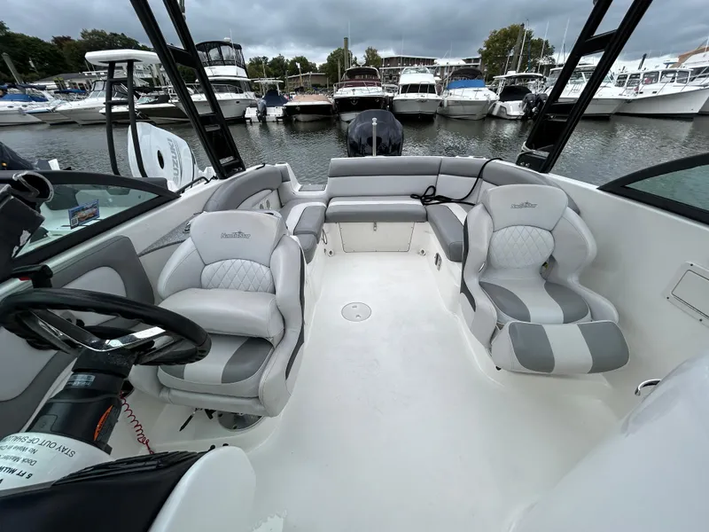 Slide: The Image of 2021 NauticStar 243 DC boat interior with plush seating at marina. - 12