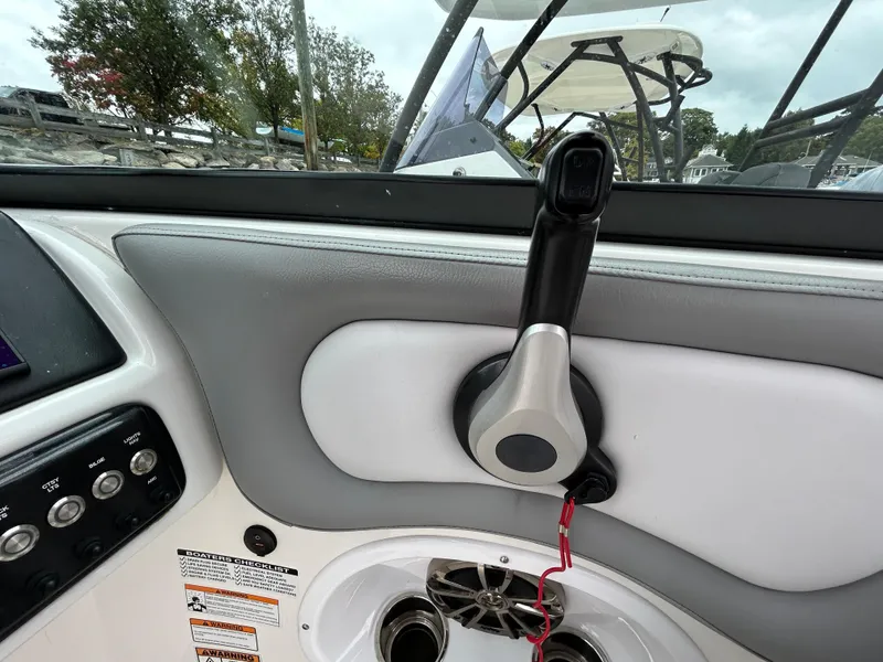 Slide: The Image of Close-up of 2021 NauticStar 243 DC boat throttle control and dashboard. - 15