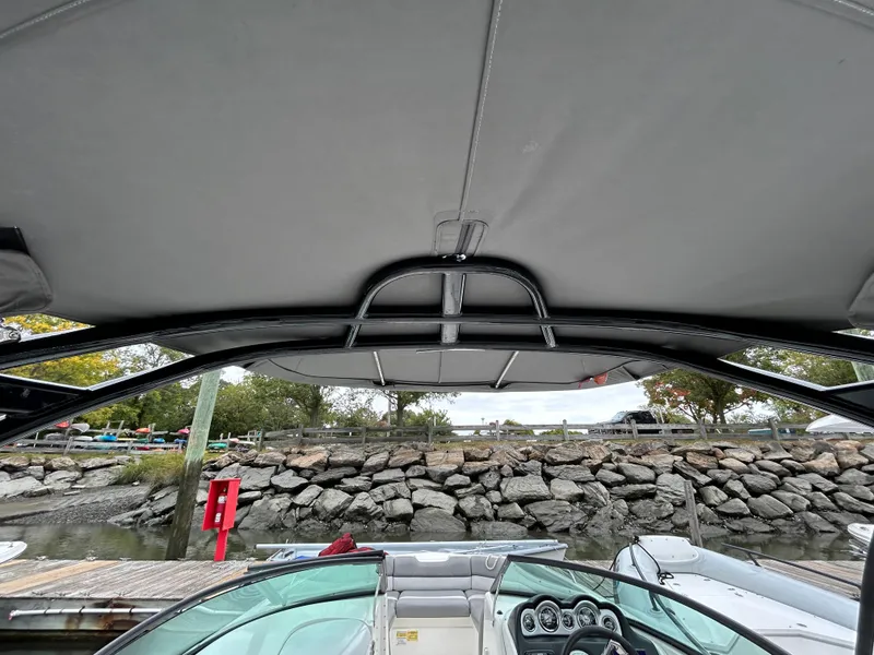 Slide: The Image of 2021 NauticStar 243 DC boat interior with canopy and dashboard view. - 25