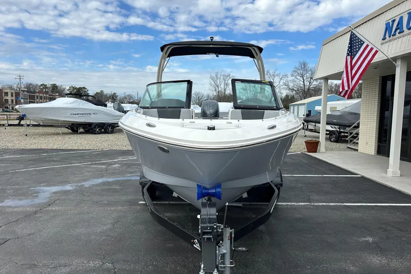 Slide: The Image of 2026 Chaparral 21 SSi OB boat on trailer at dealership, American flag displayed. - 2