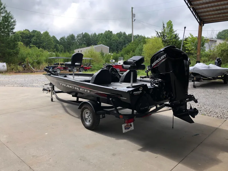 Slide: The Image of 2021 Bass Tracker PRO TEAM 175 TXW boat with Mercury engine, parked outdoors. - 2