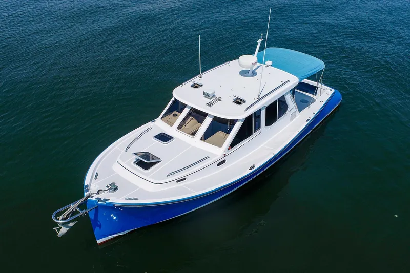 Slide: The Image of 2004 True North 38 yacht with blue hull on calm water. - 10