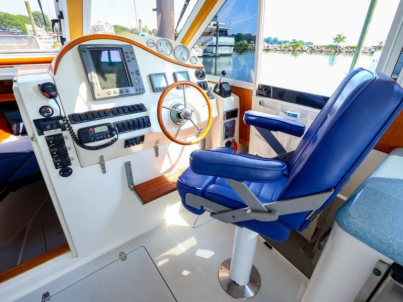 Slide: The Image of Interior of 2004 True North 38 boat with blue captain's chair and navigation controls. - 15