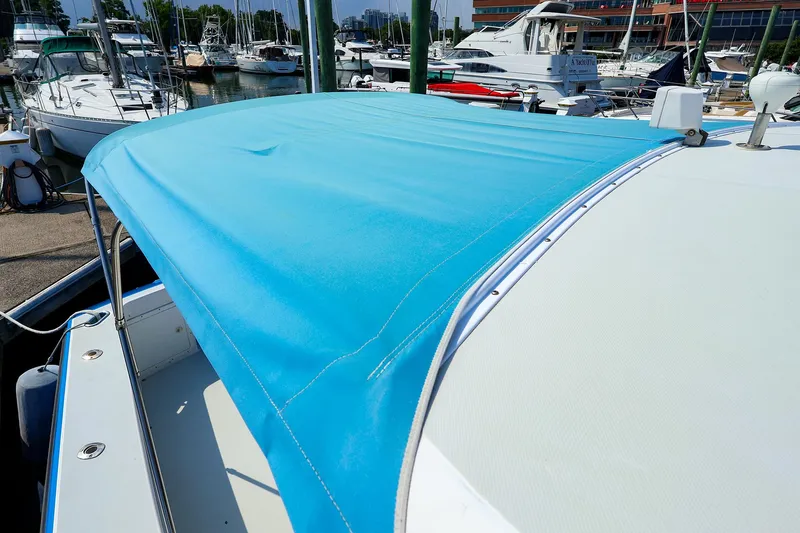 Slide: The Image of Blue canopy on a 2004 True North 38 boat docked at a marina. - 28