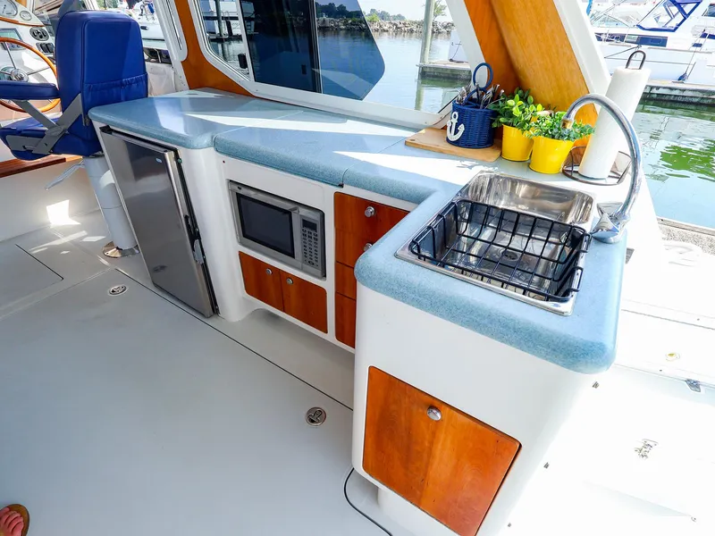 Slide: The Image of Luxurious 2004 True North 38 yacht kitchen with sink, microwave, and seating. - 32