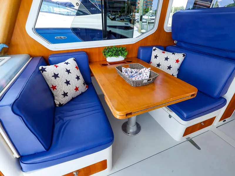 Slide: The Image of Cozy dining area on 2004 True North 38 boat with blue seating and star-patterned pillows. - 33