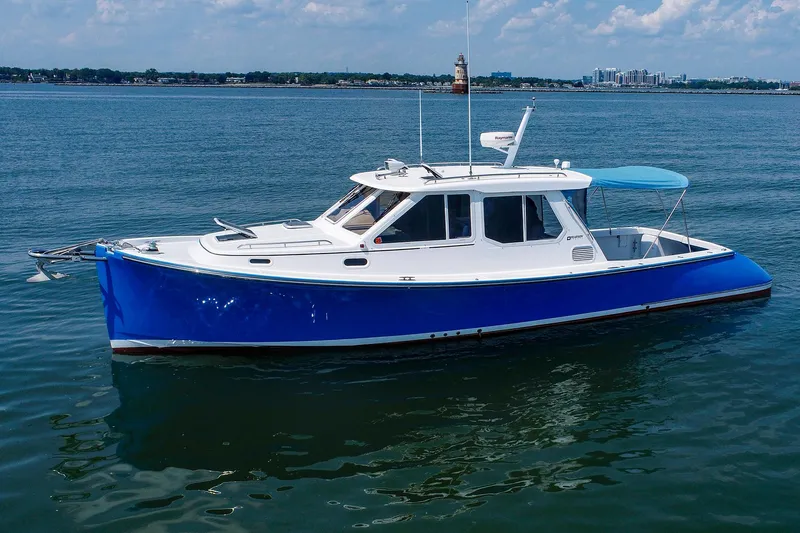Slide: The Image of 2004 True North 38 boat with blue hull on calm water. - 7