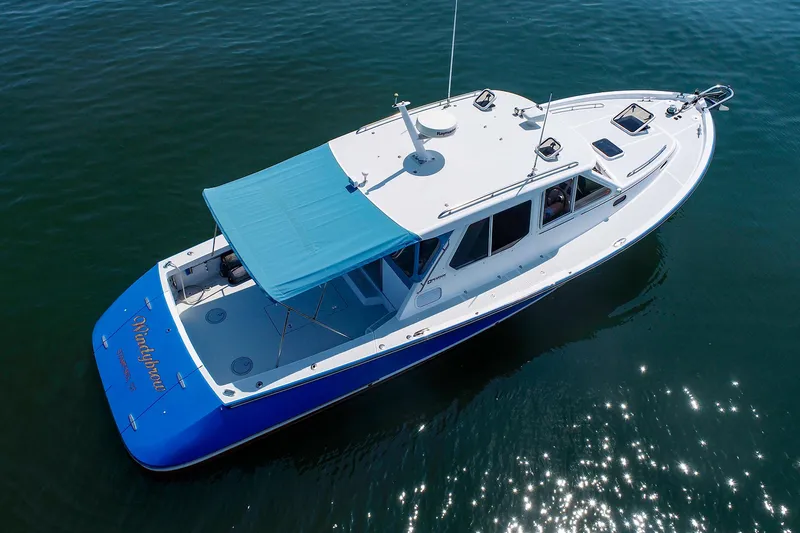 Slide: The Image of Aerial view of 2004 True North 38 boat with blue canopy on water. - 9