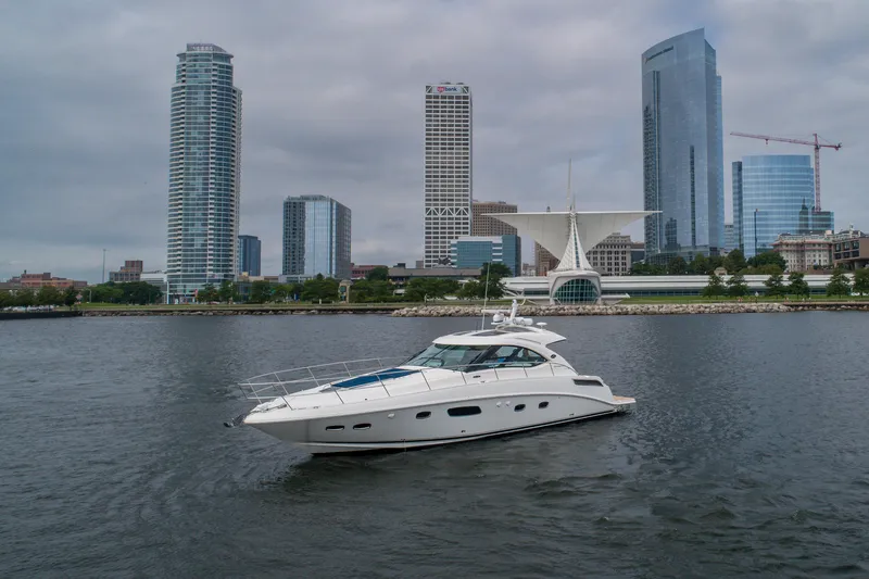 The Image of 2009 Sea Ray 470 Sundancer yacht on water with city skyline backdrop. - 0