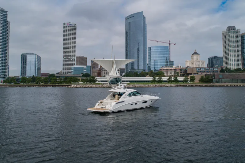 Slide: The Image of 2009 Sea Ray 470 Sundancer yacht cruising near city skyline with modern buildings. - 11