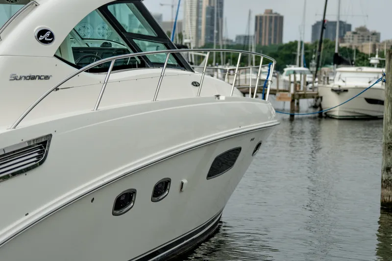 Slide: The Image of 2009 Sea Ray 470 Sundancer yacht docked in marina, city skyline in background. - 16
