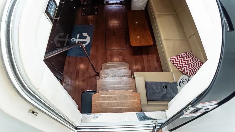 Slide: The Image of Interior view of 2009 Sea Ray 470 Sundancer yacht, featuring wooden stairs and cozy seating area. - 27