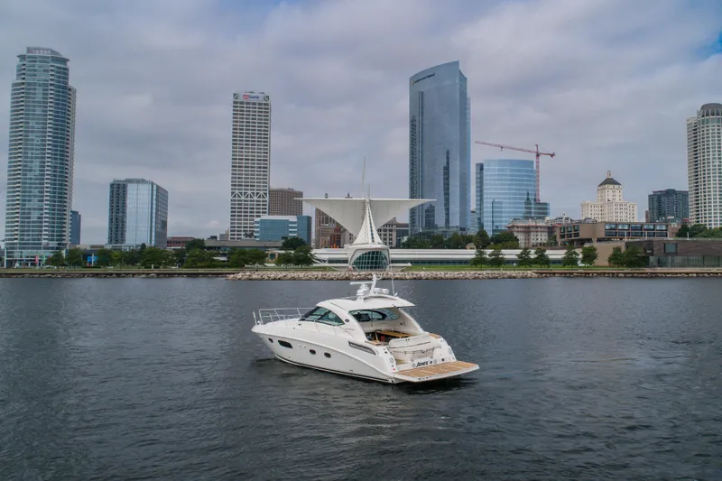 Slide: The Image of 2009 Sea Ray 470 Sundancer yacht on water with city skyline backdrop. - 9
