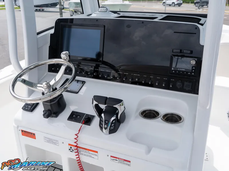 Slide: The Image of 2026 Sea Hunt Ultra 265 SE boat dashboard with steering wheel and electronic controls. - 23