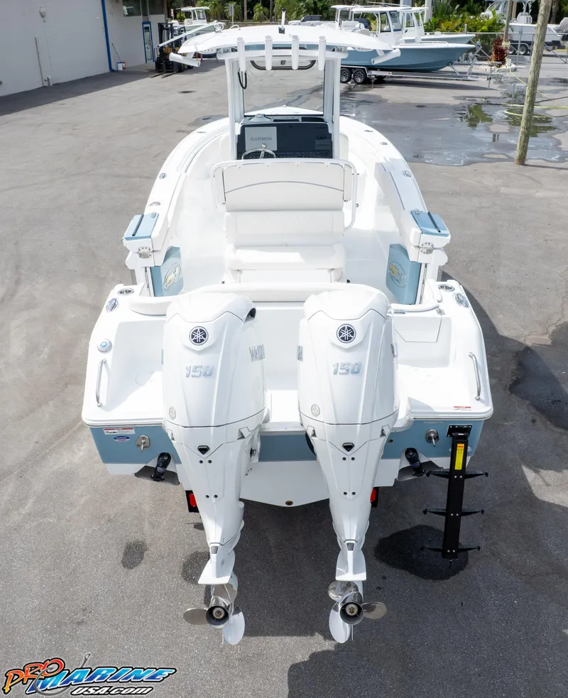 Slide: The Image of 2026 Sea Hunt Ultra 265 SE boat with dual Yamaha 150 engines, docked on pavement. - 6