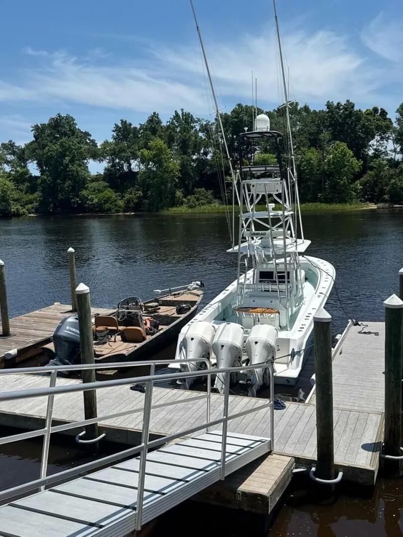 Slide: The Image of 2012 Contender 39ST boat docked by a river, surrounded by lush greenery. - 12