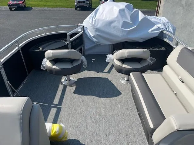 Slide: The Image of 2026 Sun Tracker Fishin' Barge 20 DLX interior with seating and covered equipment. - 10