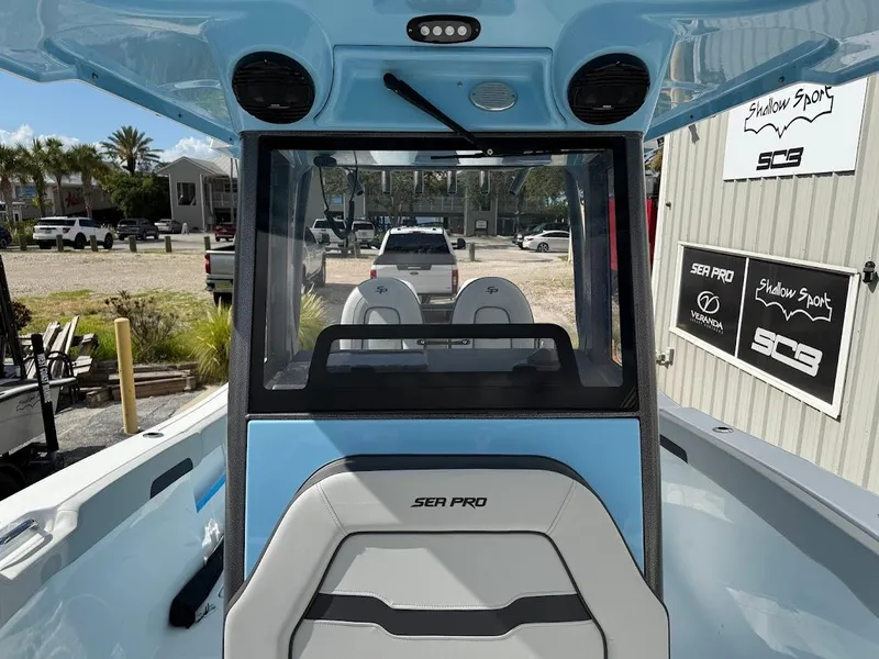 Slide: The Image of 2026 Sea Pro 262 Offshore boat interior with seating and console, parked outdoors. - 21