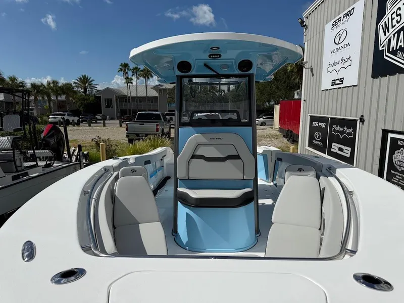 Slide: The Image of 2026 Sea Pro 262 Offshore boat with sleek design, docked near dealership under clear blue sky. - 3