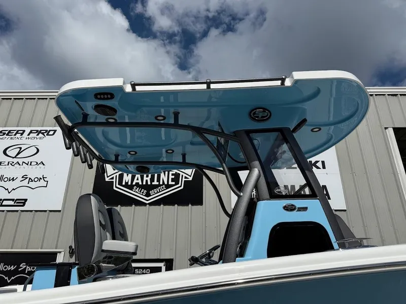 Slide: The Image of 2026 Sea Pro 262 Offshore boat with blue T-top against cloudy sky. - 5