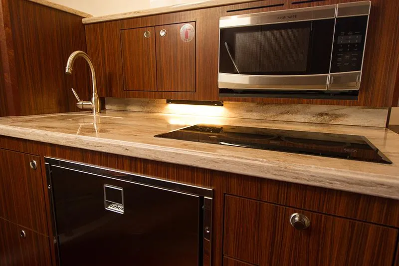 Slide: The Image of 2018 Pursuit OS 355 Offshore yacht kitchen with wood cabinetry and modern appliances. - 10