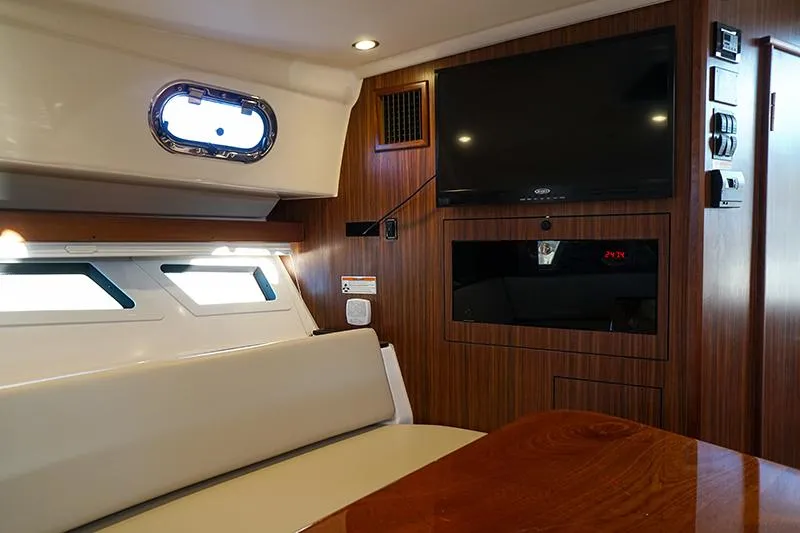Slide: The Image of 2018 Pursuit OS 355 Offshore cabin interior with TV and seating area. - 12