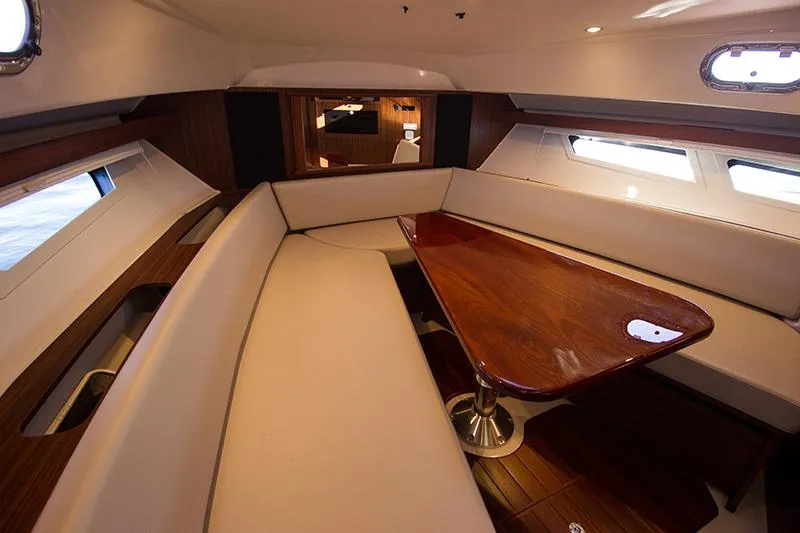 Slide: The Image of 2018 Pursuit OS 355 Offshore cabin with elegant seating and wooden table. - 13