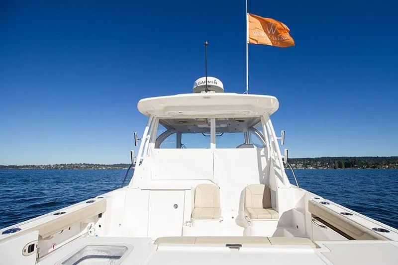 Slide: The Image of 2018 Pursuit OS 355 Offshore boat on calm water under clear blue sky. - 2