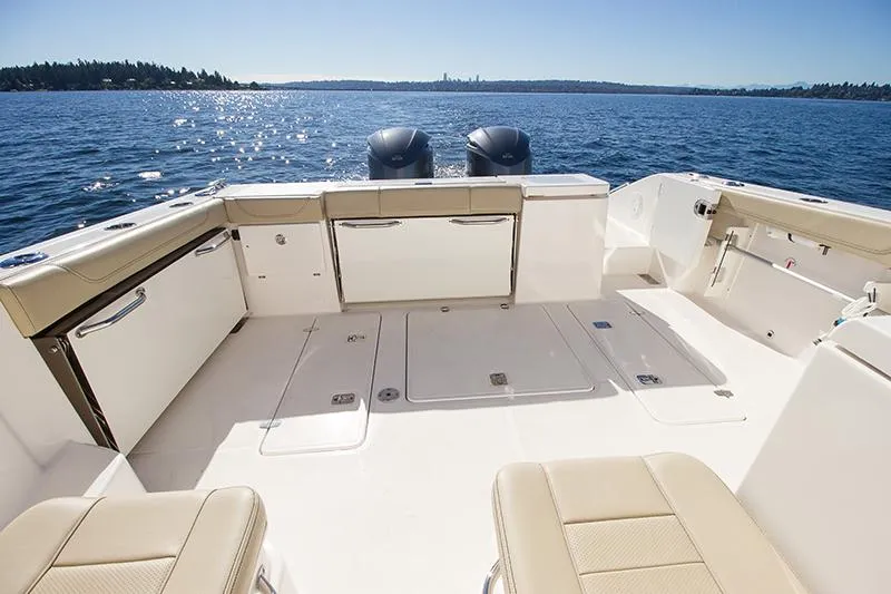 Slide: The Image of 2018 Pursuit OS 355 Offshore boat deck with twin engines on a sunny day. - 3