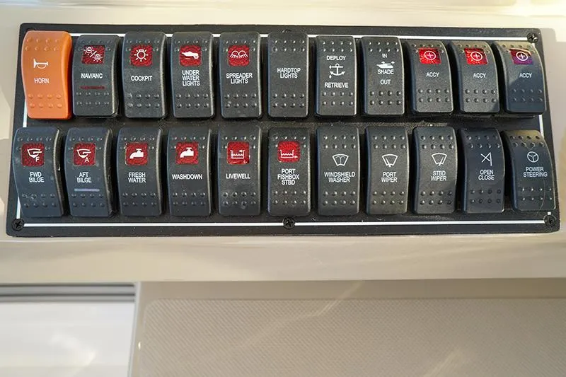 Slide: The Image of Control panel of a 2018 Pursuit OS 355 Offshore boat with labeled switches. - 6