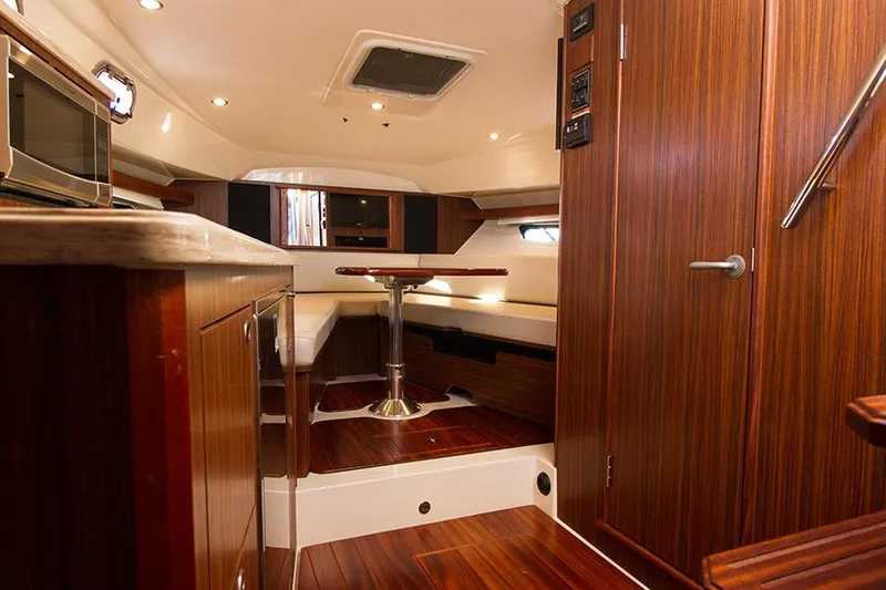 Slide: The Image of 2018 Pursuit OS 355 Offshore cabin interior with wood finish and seating area. - 8