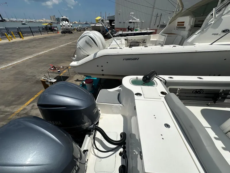 Slide: The Image of 2021 NauticStar 28XS boat with Yamaha engines docked at a marina. - 10