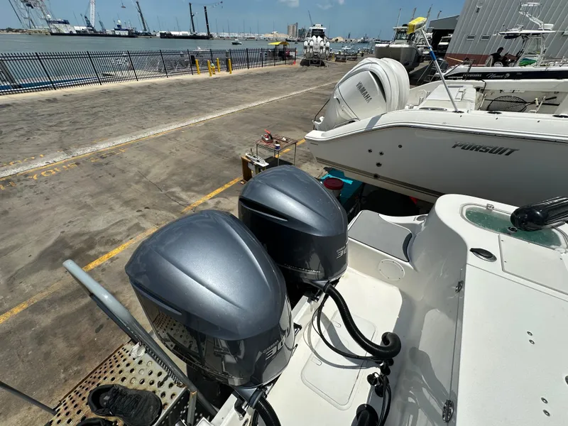 Slide: The Image of 2021 NauticStar 28XS boat with dual outboard engines at a marina dock. - 11