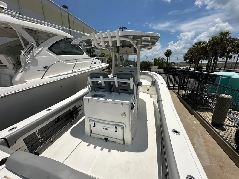 Slide: The Image of 2021 NauticStar 28XS boat with center console, docked under a sunny sky. - 13
