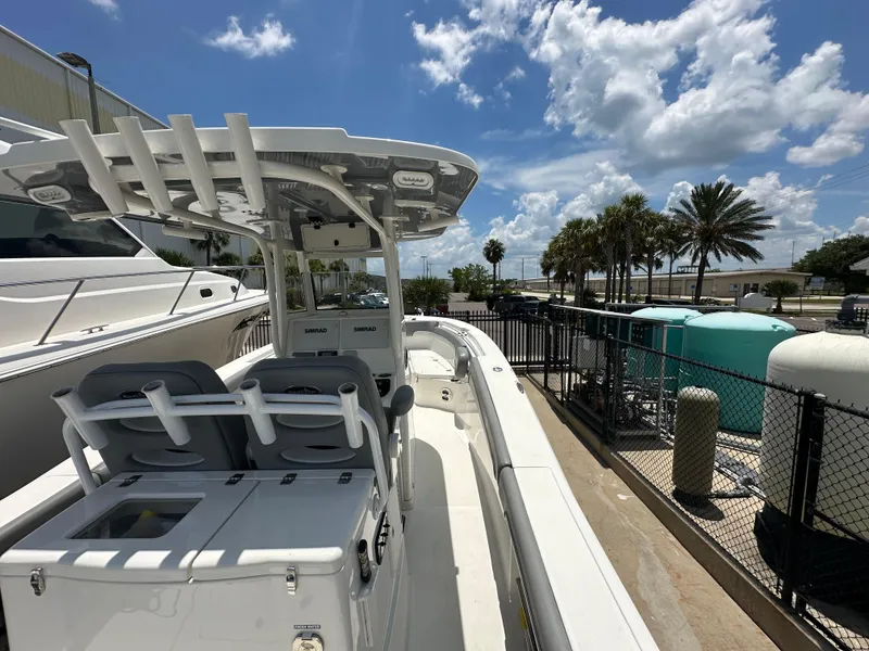 Slide: The Image of 2021 NauticStar 28XS boat docked under a sunny sky with palm trees. - 14