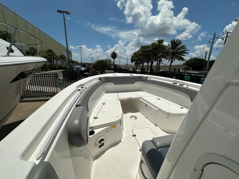 Slide: The Image of 2021 NauticStar 28XS boat interior with seating, under a partly cloudy sky. - 23