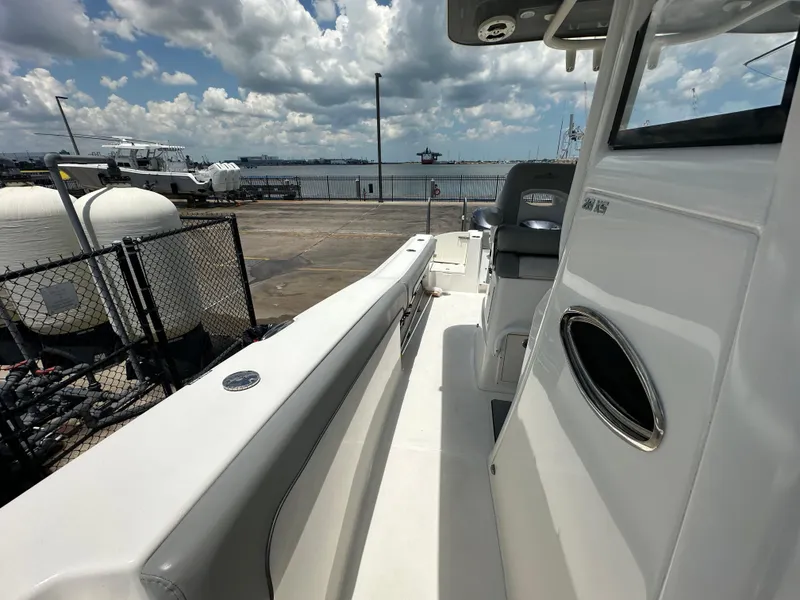 Slide: The Image of 2021 NauticStar 28XS boat docked at marina under cloudy sky. - 31