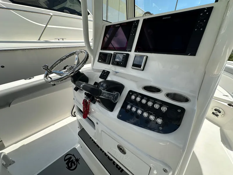 Slide: The Image of 2021 NauticStar 28XS boat console with steering wheel and electronic controls. - 38