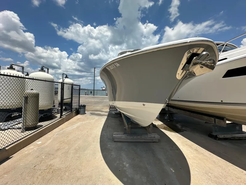 Slide: The Image of 2021 NauticStar 28XS boat on dry dock under a partly cloudy sky. - 4