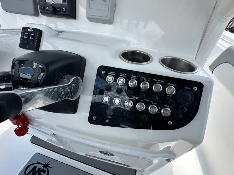 Slide: The Image of Control panel of a 2021 NauticStar 28XS boat with switches and cup holders. - 40