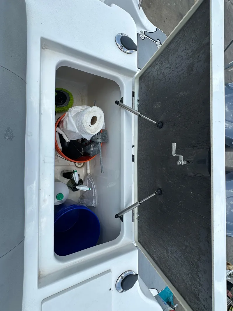 Slide: The Image of Open storage compartment on a 2021 NauticStar 28XS boat with cleaning supplies. - 45