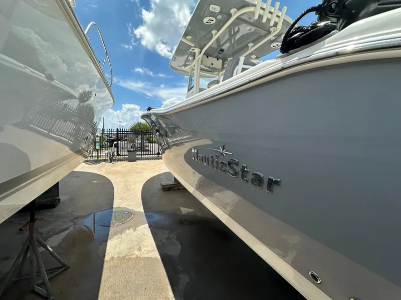 Slide: The Image of 2021 NauticStar 28XS boat in marina, sunny day, close-up view. - 7
