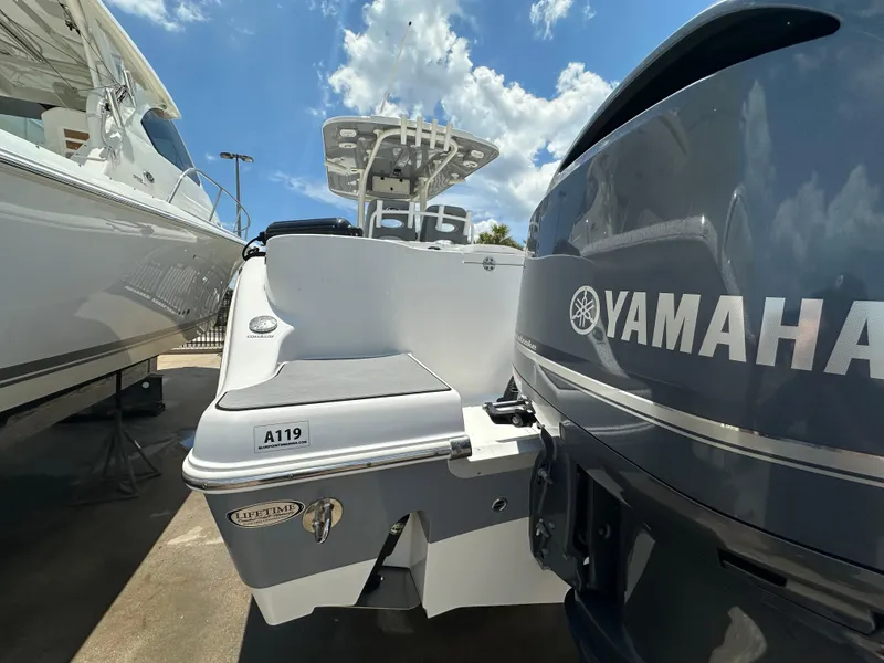 Slide: The Image of 2021 NauticStar 28XS boat with Yamaha engine, docked under a clear blue sky. - 8