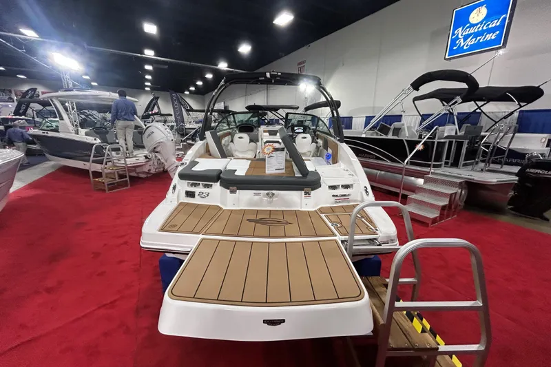 Slide: The Image of 2026 Chaparral 23 SSi boat displayed at a marine exhibition on a red carpet. - 2