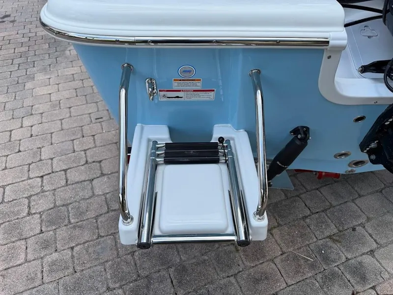 Slide: The Image of 2026 Sea Pro 210 Bay boat with stainless steel swim ladder on a paved surface. - 11