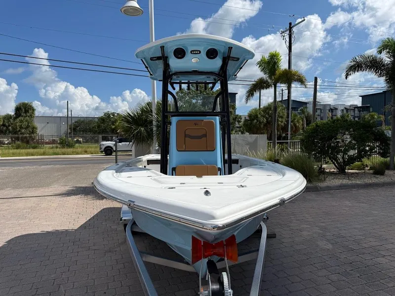 Slide: The Image of 2026 Sea Pro 210 Bay boat on trailer, parked outdoors under a blue sky. - 2
