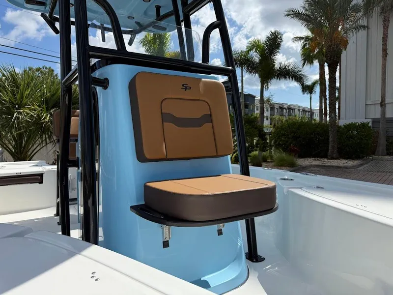 Slide: The Image of 2026 Sea Pro 210 Bay boat with tan seating, blue console, and palm trees in the background. - 4