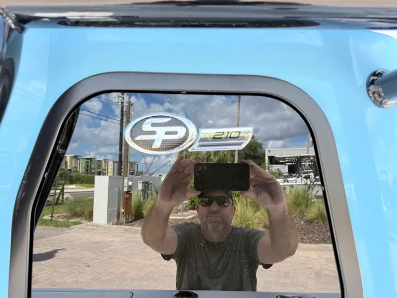 Slide: The Image of Reflection on Sea Pro 210 Bay boat window, 2026 model, with logo visible. - 6
